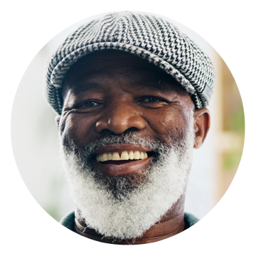Smiling older man with a white beard and flat cap